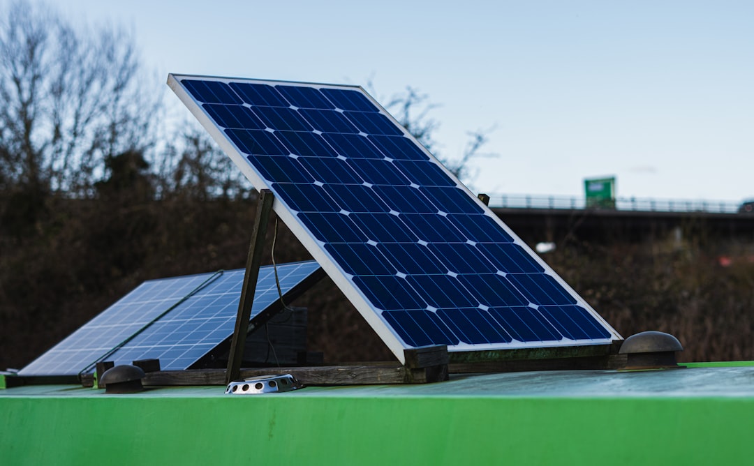 blue-and-white-solar-panel-on-green-metal-bar-during-daytime-b6vain3wynw